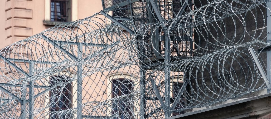 gray barbwire on fence near building during day